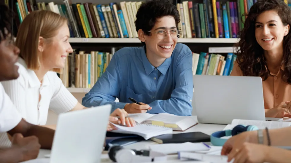 Group of diverse college students studying and laughing together